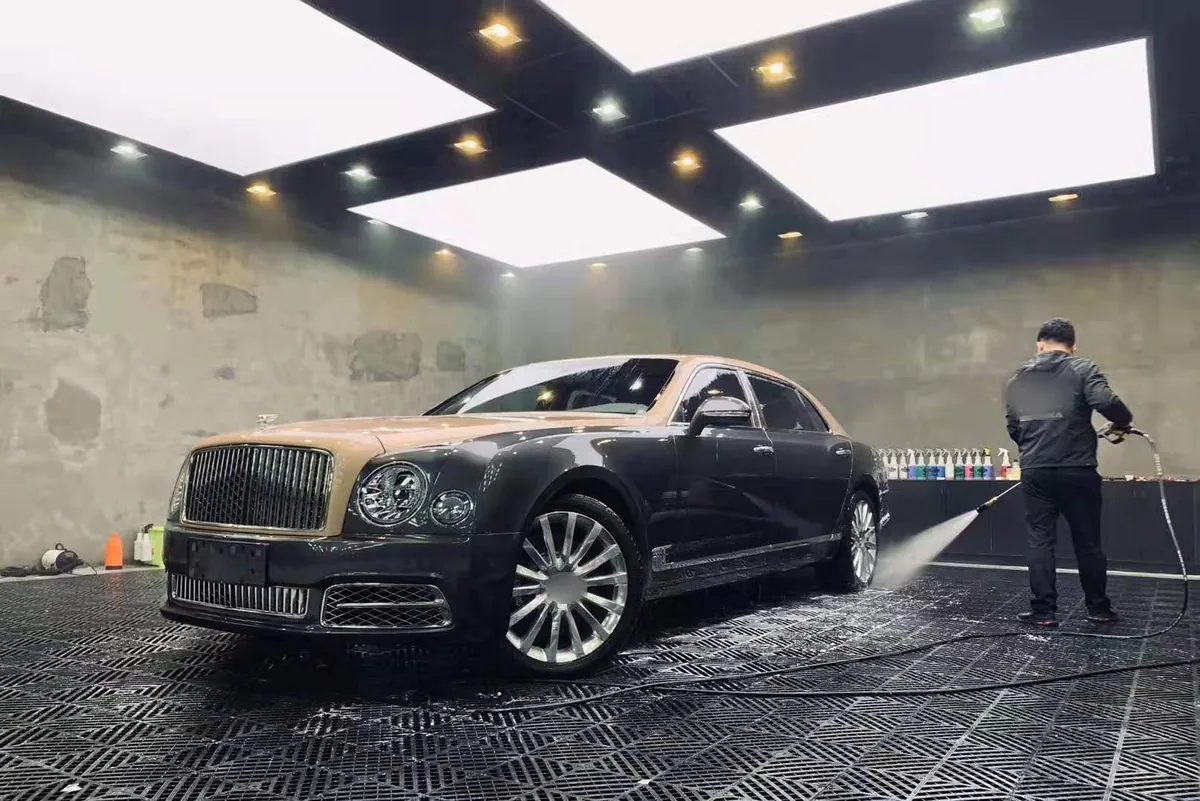 Auto de lujo en una bahía de lavado con espuma: detailing automotriz