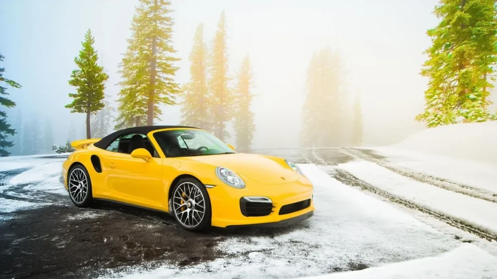 Porsche 911 Turbo amarillo con pintura brillante en un paisaje nevado