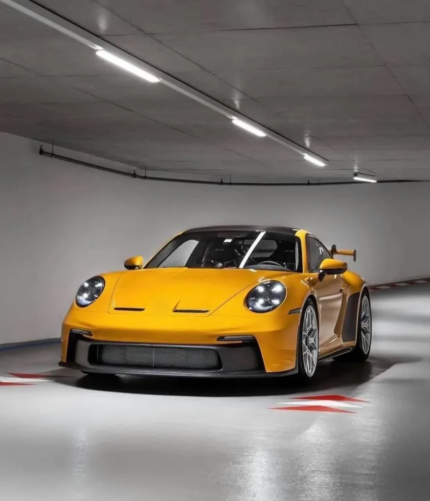 Porsche GT3 amarillo en un estacionamiento limpio