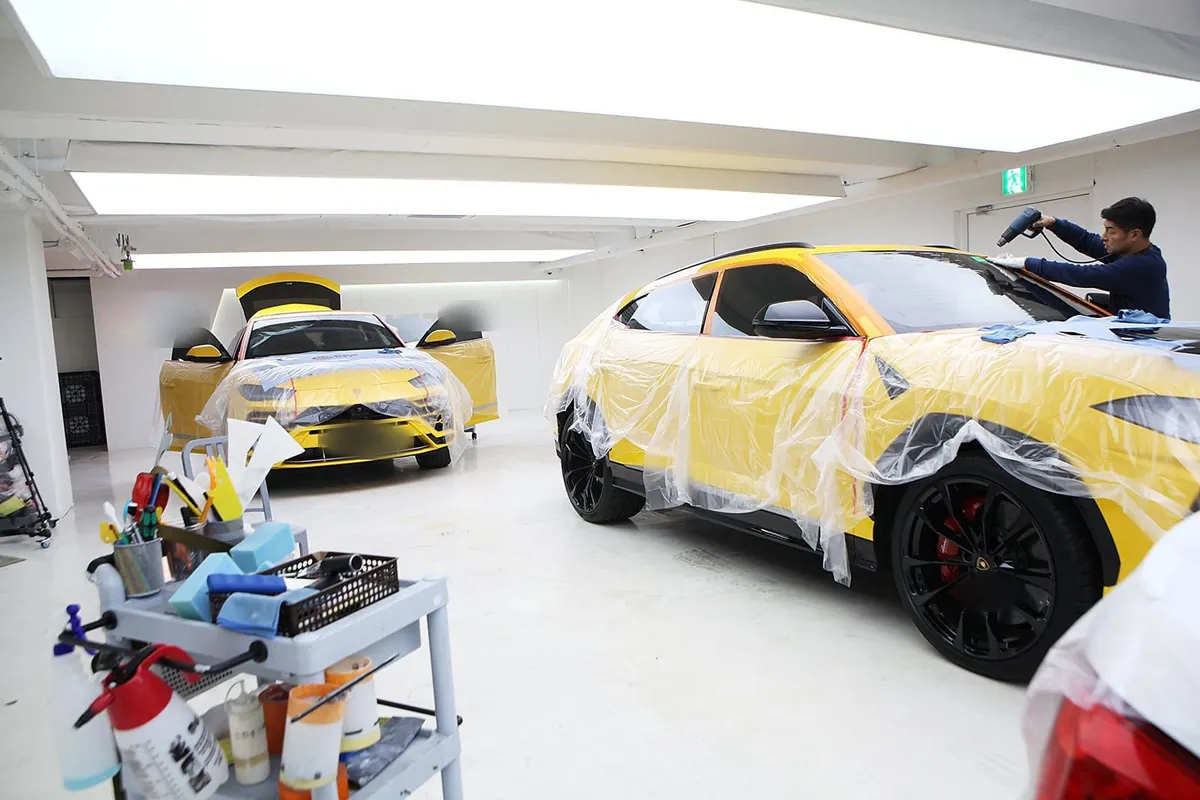 Taller de detallado con un Urus amarillo en instalación de película